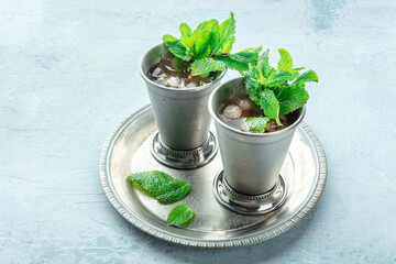 Mint Julep in the Kentucky Derby classic silver glass, with fresh mint leaves, on a tray
