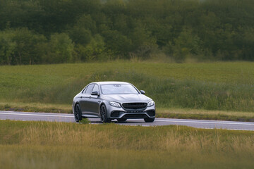 Fototapeta premium Executive sedan driving along scenic highway