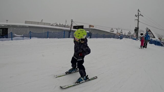 Skiing lessons for kids in snowy conditions at a winter sports location