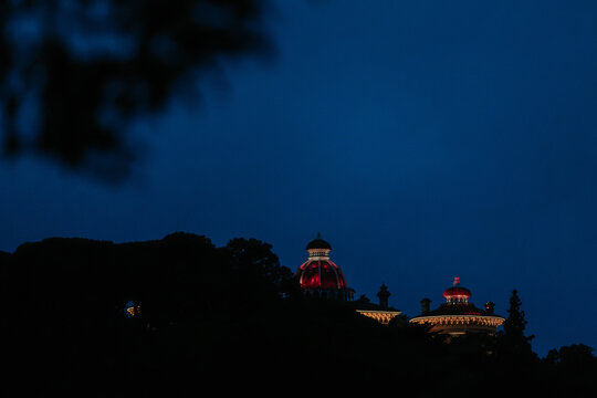 Illuminated domes in Palacio Da Pena against night sky