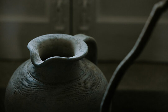 Vintage clay pitcher in dimly lit setting