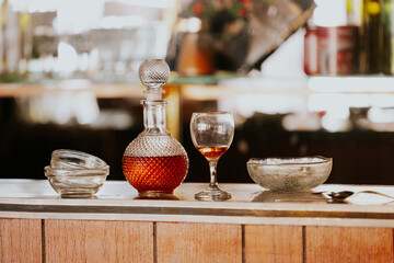 Elegant glassware with decanter and drink on bar counter