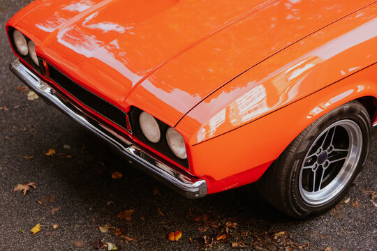 Vintage orange car with chrome details on street