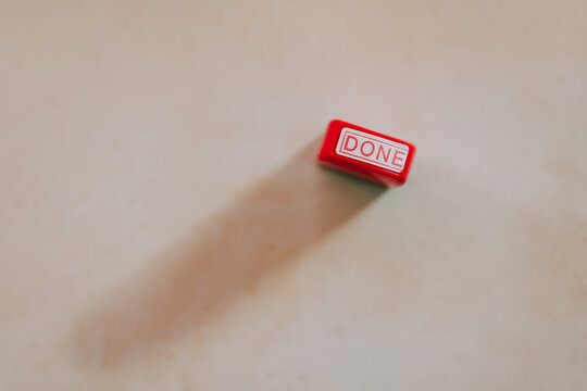 Red done stamp on a plain surface with shadow