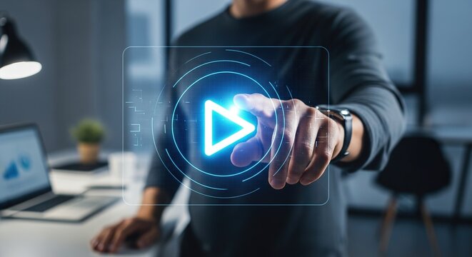 A person's hand interacting with a glowing blue digital play button in a modern office setting, symbolizing starting or launching.