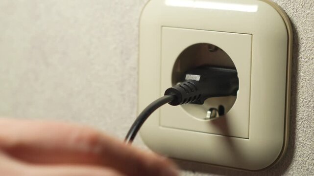 A close-up of a wall outlet.
Plugging an electrical plug into a wall outlet.
Using electrical devices