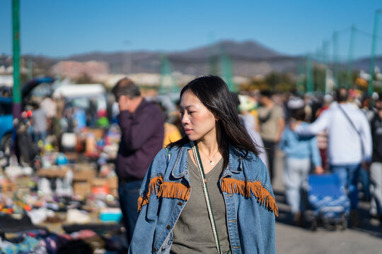 Woman exploring local flea market in denim jacket