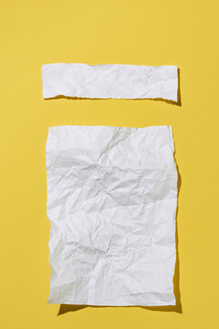 Minimal setup with crumpled papers on yellow background