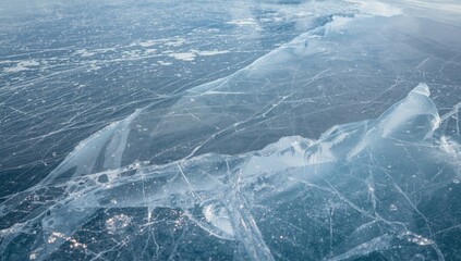 Frozen lake with visible ice cracks, highlighting natural processes during winter transition