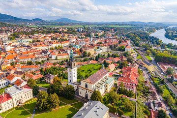Aerial view of St. Stephen's Cathedral in Litomerice shows its impressive architecture and surrounding scenery. The drone captures the vibrant colors of the city and the lush greenery nearby.