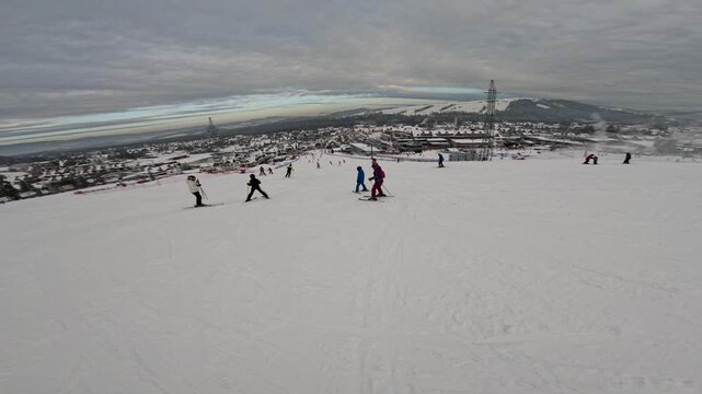 Skiing activity at a mountain resort on a cloudy day