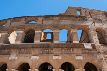 Obraz premium Italy - Rome - Colosseum - Exterior tiered wall with arches and stone openings showing the ancient Roman amphitheater architecture.