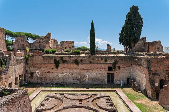 Italy - Rome - Domus Augustana - Ancient Roman palace courtyard with a pool, cypress trees, and brick ruins on the Palatine Hill site.