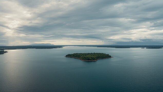 A broad landscape scene showing a cloudy sky over a sizable lake from a wide-angle shot, focusing on atmospheric weather