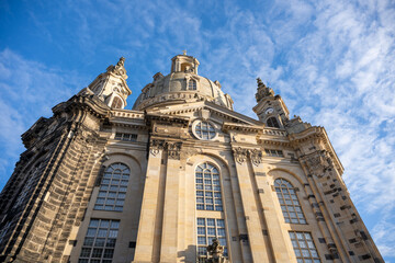 Frauenkirche is a church in Dresden, Germany. It features a large dome and stands tall against a blue sky. People visit this site during Christmas celebrations each year.