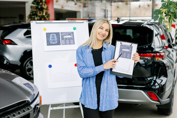 Saleswoman showing infographic during presentation about automotive suspension performance in car dealership
