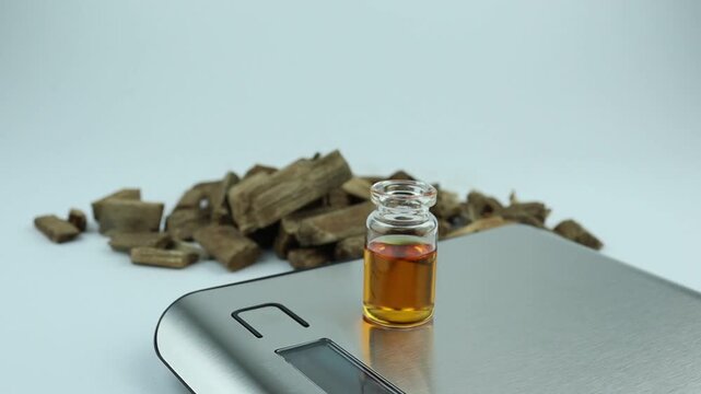 essential oil bottle , chemical beaker , flask on digital scale white table with blotting paper , and fragrance bottle used to blend nice scent smell for perfume and candle by perfumer in laboratory