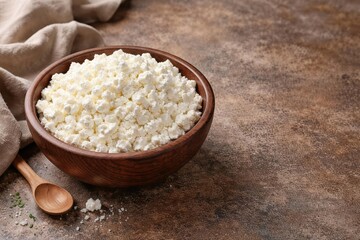 Bowl filled with fresh cottage cheese on a textured rustic surface with copy space