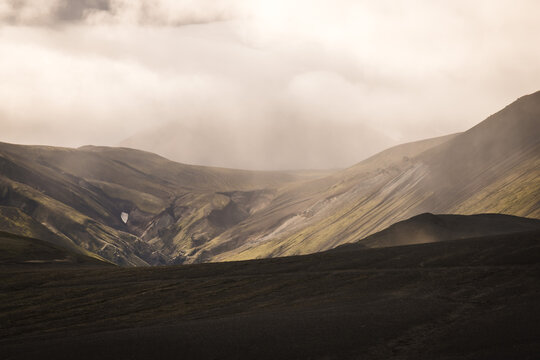 View of striking mountain landscapes bathed in soft light, with dramatic shadows and rugged terrain conveying the raw beauty, Landmannalaugar, The Central Highland, Iceland.