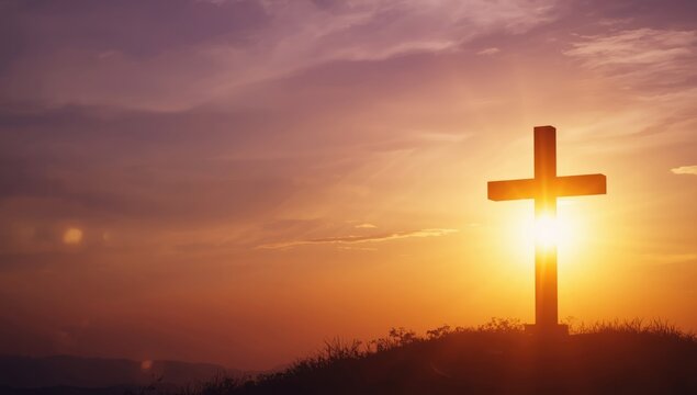 Sunrise with shining bokeh and silhouette of Jesus Christ alongside a holy cross, used as a spiritual background