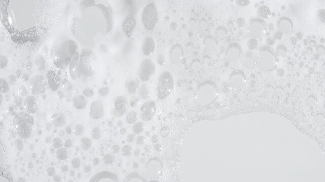 Bubbles of white soap foam. Moving Soap foam popping bubble on a white backdrop. Soap sud macro structure. Clean, cleaning concept, laundry, shower. . High quality 4k footage