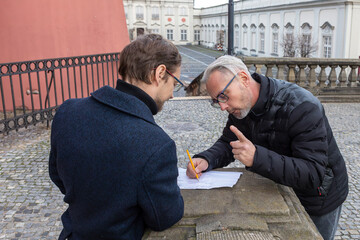 Two people engaged in conversation while reviewing documents in a public space