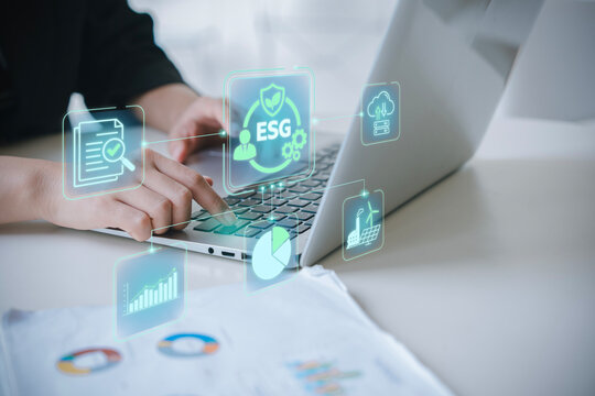 Business person analyzing ESG reporting and sustainability audit data on digital devices for corporate social responsibility and net zero goals