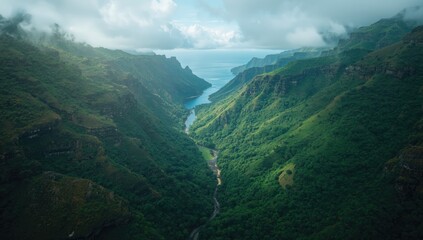 Bird's-eye perspective of green forest and vibrant mountain valley with cliffs and water, highlighting conservation, Earth Day