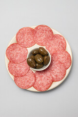 Thinly sliced salami sausage on a plate, top view