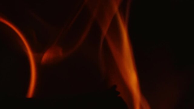 Log Burning with Bright Hot Burning Fire Flames Isolated on Black Background. Smooth Flowing Abstract Motion. Beautiful Twisting Flickering Glow.