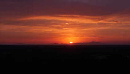 Dusk landscape featuring intense orange colors, shadowed silhouettes, and the enchanting glow of sunset lighting
