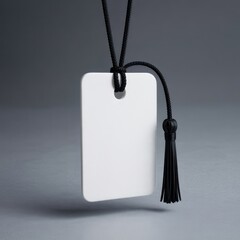 White rectangular tag with black tassel and cord on gray background blank rounded corners