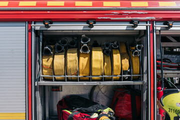 Obraz premium Fire truck compartment storing rolled up yellow hoses and equipment