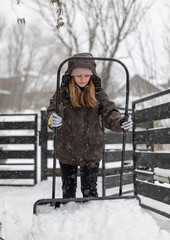 Shoveling snow from a driveway after a heavy snowfall, woman with a snow shovel