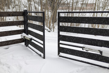 The double-leaf gate on the driveway to the property is blocked by snow and cannot be opened