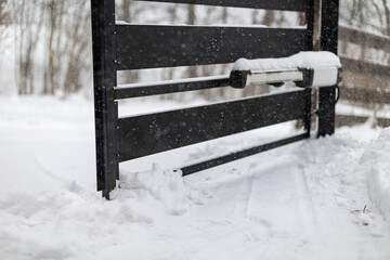 The double-leaf gate on the driveway to the property is blocked by snow and cannot be opened