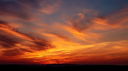 Fototapeta premium Fiery Sunset Sky with Dramatic Orange and Red Clouds Above Silhouette