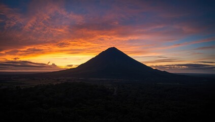 Obraz premium Arenal Volcano at dusk in Costa Rica, with vibrant sunset colors reflecting on the terrain