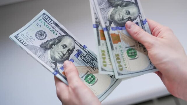 Close up woman's hands counting money one hundred dollars banknotes after get paid. Female calculates cash, income, salary, profit, want to buy something.