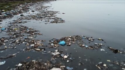 Severe water pollution from extensive plastic and garbage littering a contaminated body of water, highlighting critical environmental impact and urgent waste management