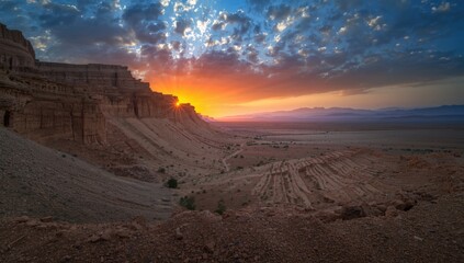 Evening light bathes the Negev desert landscape surrounding Makhtesh Ramon crater, highlighting geological formations