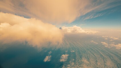 Fototapeta premium Bird's-eye perspective of a vibrant landscape featuring clear blue sky, golden clouds, and ocean, highlighting geographic features