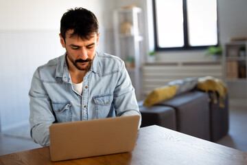 Confident digital nomad man working online from home, embracing freedom, flexibility