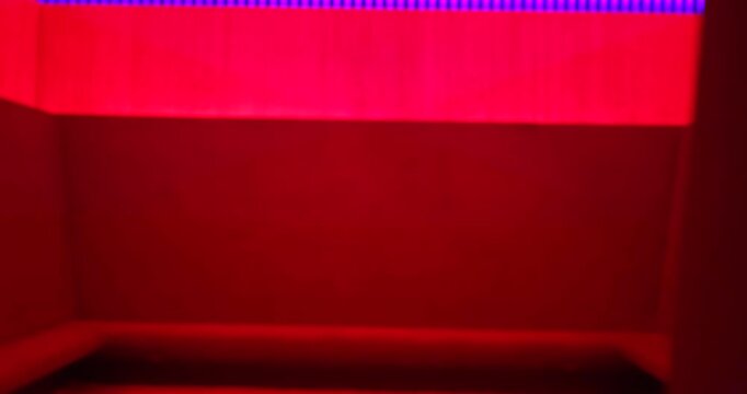 A multicolored light structure with wooden railings at night, concept artsy architecture shot