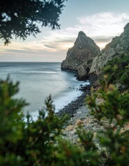 Fototapeta premium Serene Coastal Landscape with Rocky Outcrop at Sunset