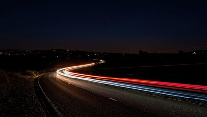 Nighttime long exposure of a roadway with streaks of headlights from moving vehicles, capturing dynamic light trails