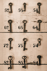 Weathered wooden panel with vintage hotel room keys