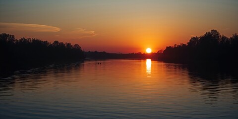 Obraz premium River sunset with water reflecting the sky and trees, warm lighting and vibrant colors, suitable for landscape backdrops