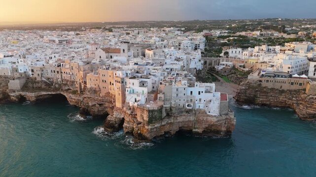 Polignano a Mare old town on the Adriatic coast, Apulia Italy. Aerial View of white cliffside houses above turquoise Mediterranean Sea and dramatic limestone coastline