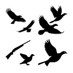 Obraz premium Dynamic silhouettes of diverse birds in flight with a hunting rifle, capturing the essence of bird hunting